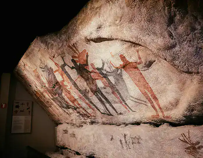 Prehistoric cave paintings depicting early human figures and animals at Lascaux.