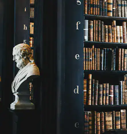 Historic 365 library with vintage books and a marble bust sculpture.